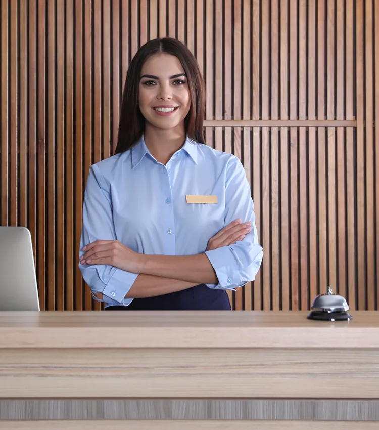 Portrait of a receptionist at desk in lobby in front of wood slatted wall
