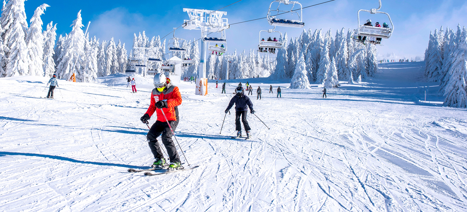 People enjoying skiing and snowboarding in mountain ski resort