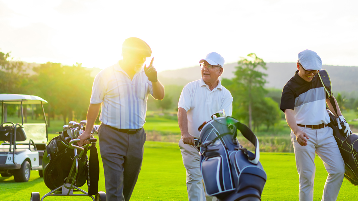 Small group of men at the end of a day of golfing.