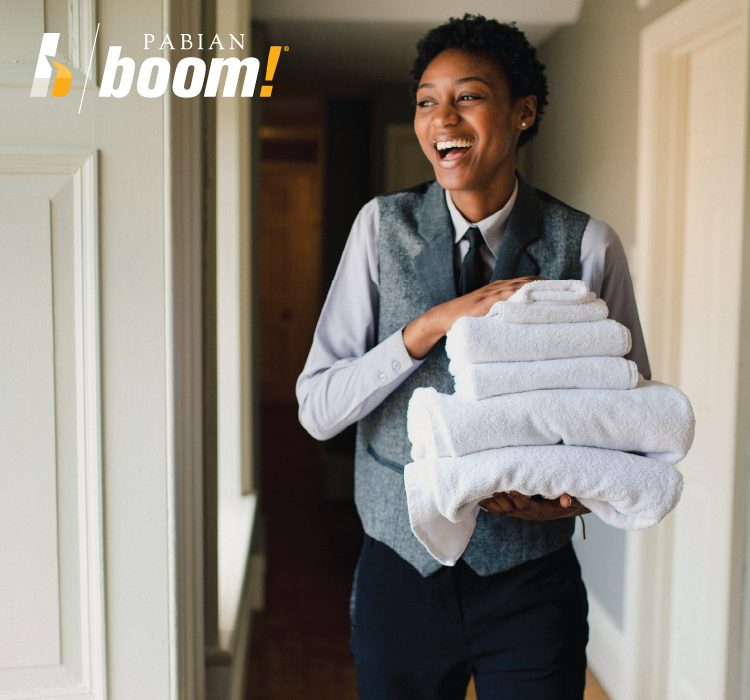 Women smiling holding folded towel for house keeping in a hotel