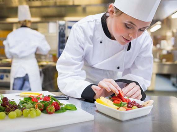 Female chef preparing food in hotel kitchen